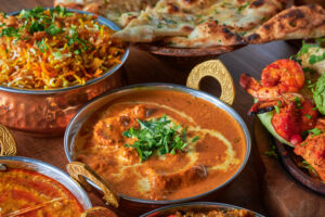 Assorterte indiske retter: butter chicken, tandoori-reker, biryani, naan og sauser.