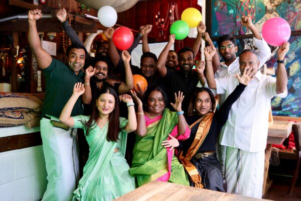 Ansatte fra Curry and Ketchup i Majorstuen – smilende familie- og teammedlemmer feirer med fargerike ballonger i den varme, asiatiske restaurant-stemningen.