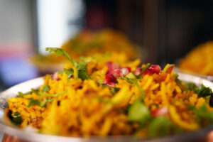 Nærbilde av fargerik biryani med safranris, granateplekjerner og koriander hos Curry & Ketchup i Oslo